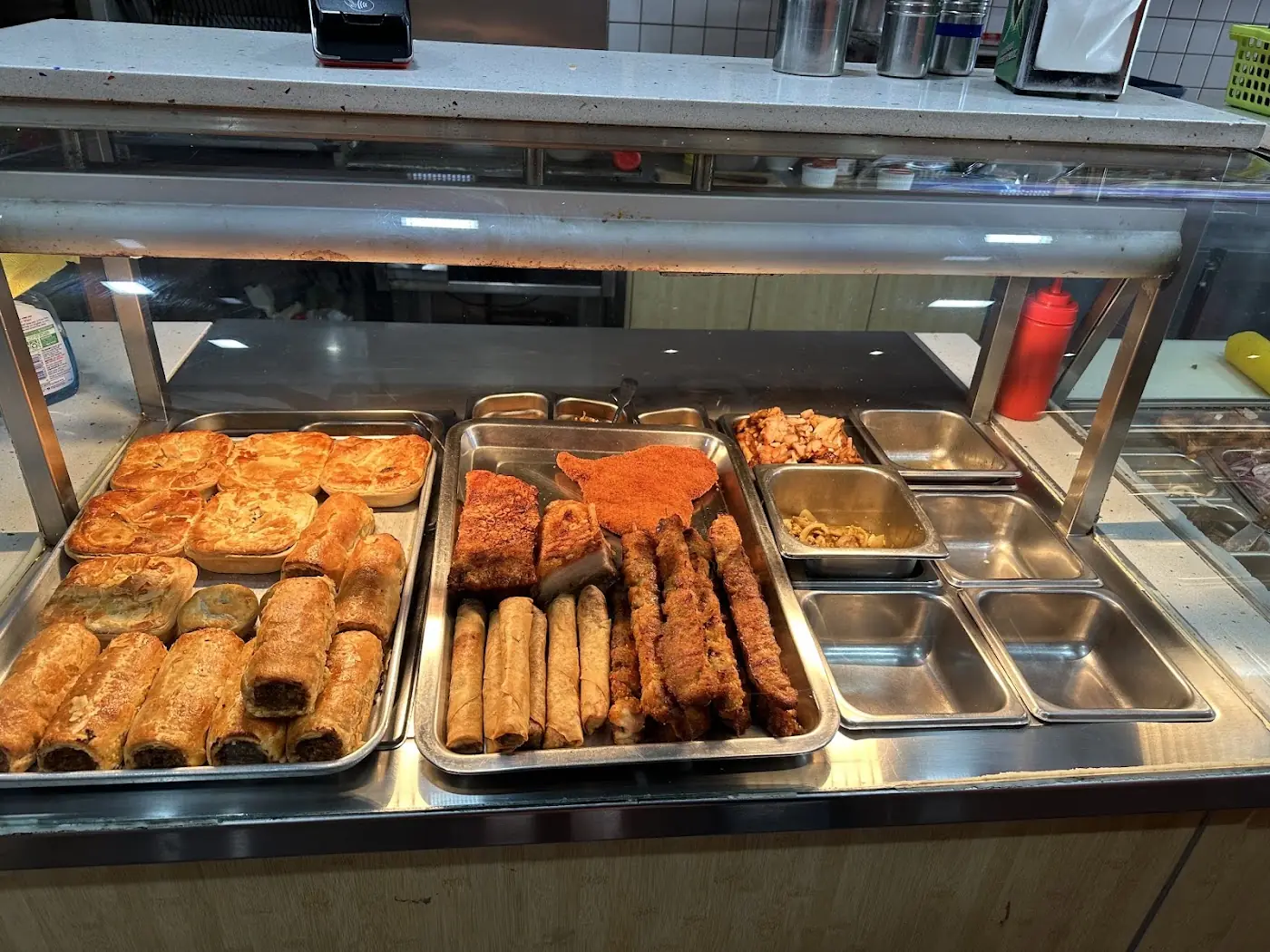 Hot trays of spring rolls and pastries in the warmer